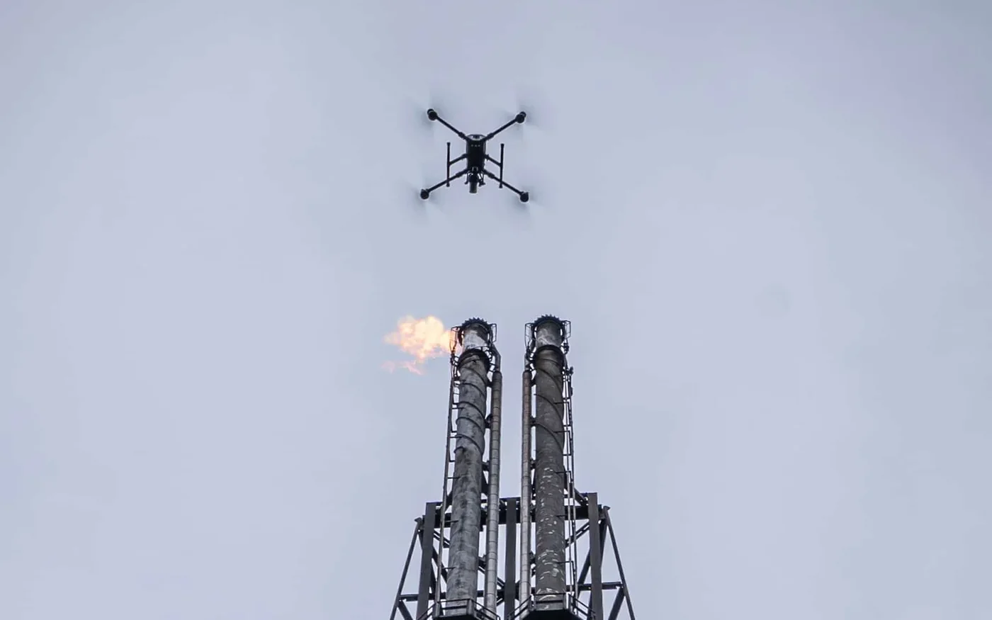 Drone inspecting a twin flare stack in flight
